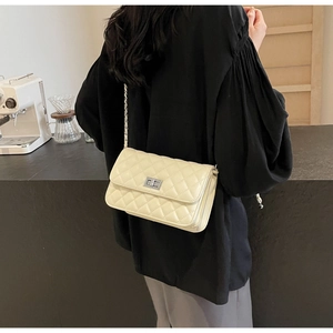 Detailansicht der gesteppten Kettentasche in Beige, die von einem Model getragen wird
