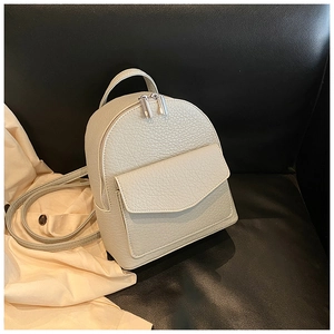 Macro detail of creamy white lychee grain leather mini backpack with silver metal zippers