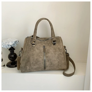 Detailed view of large tote bag in dark khaki faux suede with vertical zip and metal rings