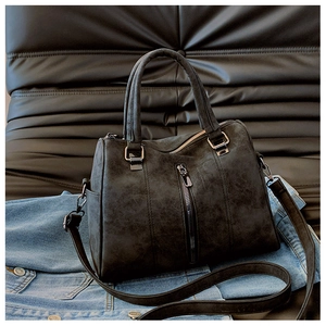 Detail of dark grey frosted leather tote bag featuring metal zipper and side pocket