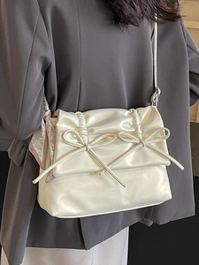 Cream pleated tote bag with bow details and heart silk scarf shown on casual outfit
