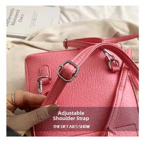 Detail of adjustable shoulder strap and silver metal buckle on a pink leather mini backpack