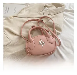 Close-up of pink leather mini crossbody bag with unique silver metal hardware and handle