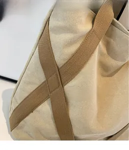 Detailaufnahme der ordentlichen Nähte und der dichten Textur einer beigefarbenen Canvas-Tasche