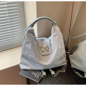 Détail du sac hobo bleu clair avec nœud argenté et bandoulière en chaîne métal
