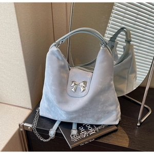 Détail du sac hobo bleu clair avec fermoir nœud argenté et bandoulière en chaîne
