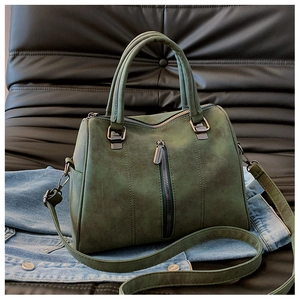 Close-up of retro dark green Boston bag with vintage leather texture and silver zipper