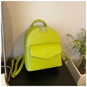 Detail of lime green pebble leather backpack featuring silver dual zippers and front flap pocket