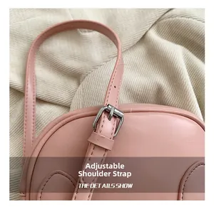 Detailed shot of pink faux leather bag with adjustable silver buckle shoulder strap