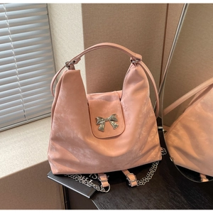 Détail du sac rose en daim avec boucle nœud papillon argentée et bandoulière chaîne
