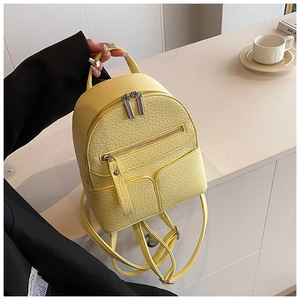 Detail of yellow pebbled PU leather mini backpack with dual metal zippers and straps