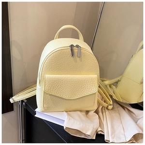 Close-up of pale yellow pleated backpack showing high-quality lychee grain leather texture