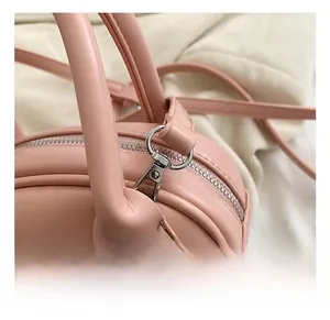 Detailed close-up of pink leather bag featuring silver metal swivel hook and zipper hardware