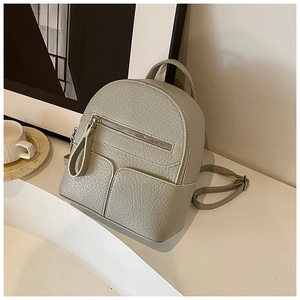 Detailed macro view of pebble-textured grey-green mini backpack with metal zipper