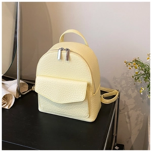 Detailed macro view of light yellow pleated backpack with silver zipper and lychee texture