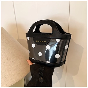 Detailed close-up of a mini bucket bag with black polka dots on transparent PVC material