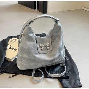 Détail du sac cabas demi-lune argenté avec nœud métallique et bandoulière réglable