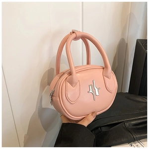 Detail shot of the pink leather oval handbag with silver cross metal hardware and top handles