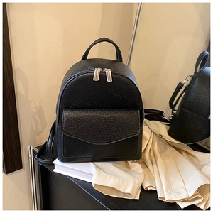 Detail of black pebbled leather mini backpack with silver zipper and front flap pocket