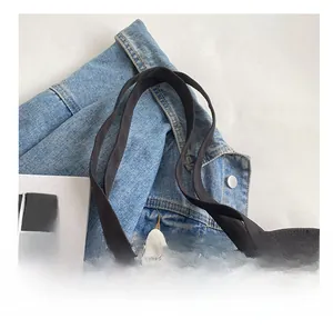 Détail de la large poignée confortable d'un sac à bandoulière en toile plissée noire