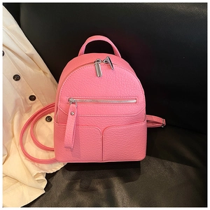 Detail of pink mini backpack with lychee leather texture and silver zipper hardware