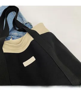 Detail of canvas tote bag showing two-tone fabric texture and contrast brand label