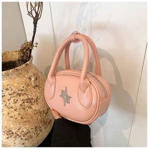 Detail of pink leather handbag featuring silver cross hardware and sturdy top handles