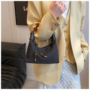 Detail of black embroidered Boston bag with amber bead accents and leather trim