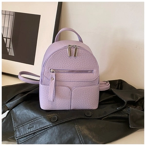 Detail view of purple lychee grain leather mini backpack on a black jacket