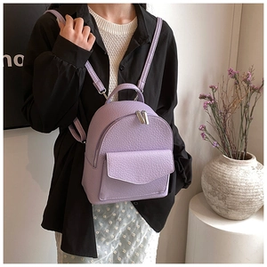 Detail of light purple pleated mini backpack with lychee leather texture and silver chain