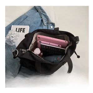 Vue intérieure du grand sac cabas en toile noire avec livres et rangement tablette