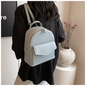 Detail of light blue faux leather backpack with silver hardware and pleated ballet style