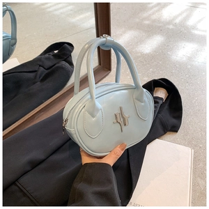Detail view of a light blue oval handbag with silver cross metal hardware and top zipper