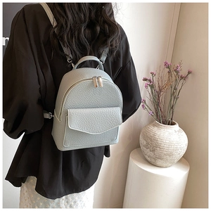 Detail of light blue mini backpack with lychee texture and silver double zippers