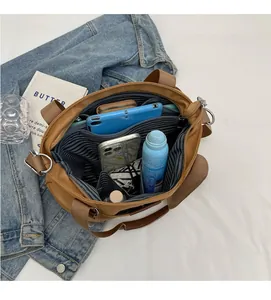 Detailed interior of tan nylon tote bag with striped lining and zipper compartments