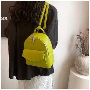 Litchi pattern green rucksack backpack shown on model in a minimalist setting