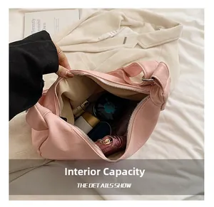 Vue détaillée du sac à bandoulière en cuir rose avec intérieur spacieux et doublure claire