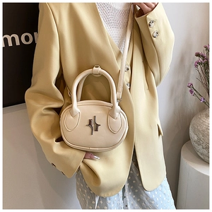 Close-up of a cream-white mini crossbody bag with a silver star metallic buckle detail