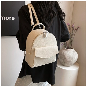 Detail of beige pleated ballet-style backpack with lychee leather texture on a model