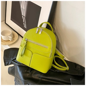 Detail of lime green mini backpack featuring pebble leather texture and silver hardware
