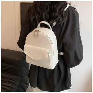 Close-up of white pleated backpack featuring premium lychee pattern texture and silver hardware