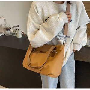 Detail of caramel tote bag with wide adjustable shoulder strap and spacious front pocket