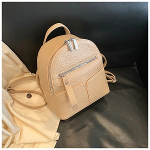 Detail of beige litchi leather mini backpack with silver metal zippers and adjustable straps