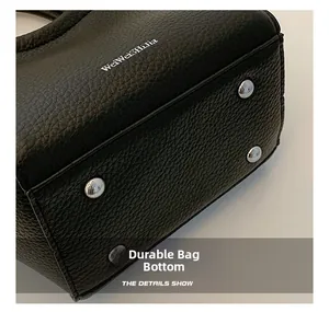 Vue détaillée du fond du sac en cuir noir avec des clous de protection en métal argenté