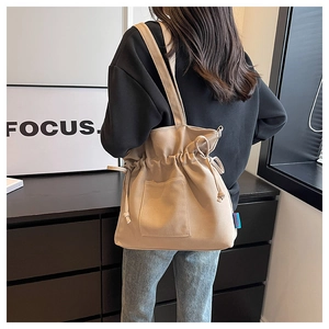 Détail du sac fourre-tout en toile kaki avec cordon de serrage plissé et poche extérieure