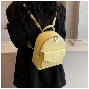 Close-up of yellow lychee pattern mini backpack with silver double zippers on model