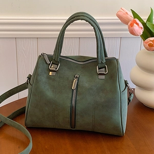 Dark green faux suede large tote bag with top handles and shoulder strap on table