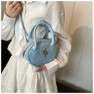 Close-up of light blue patent leather handbag with silver logo on a white outfit