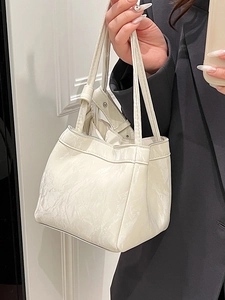 Elegante borsa tote bianca a pieghe con finitura lucida portata a mano con stile