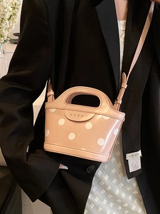 Pink polka dot bucket bag with gold logo handle and crossbody strap for women